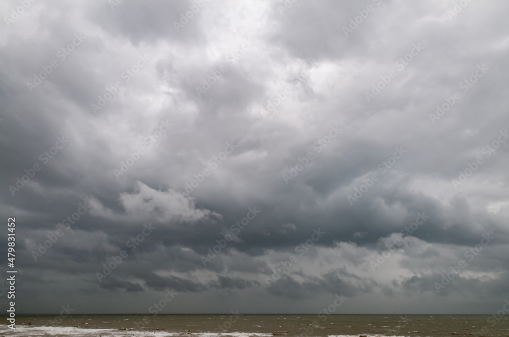 Obraz premium View over the sea to dramatic looking storm clouds. Dark dramatic lonely sea landscape. 
