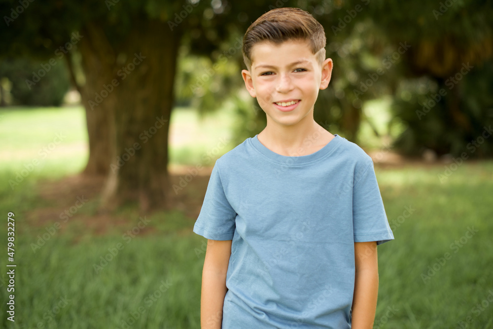 Caucasian little kid boy wearing blue T-shirt standing outdoor with a happy and cool smile on face. Lucky person. Caucasian little kid boy wearing blue T-shirt standing outdoor with a happy and cool smile on face. Lucky person.