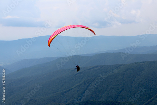 Paragliding in clouds above the mountines