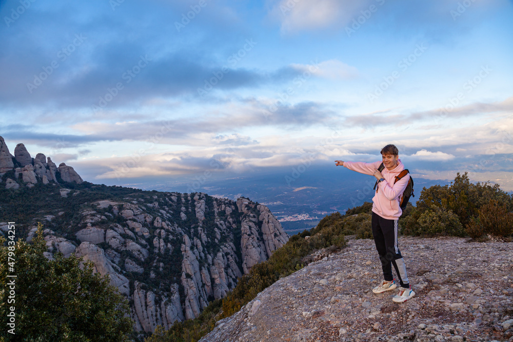 Fototapeta premium The young man looks at the mountains. Landscape with mountains and tourist Montserrat Spain.
