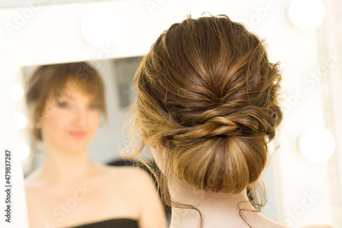 The stylist performs the hairstyle, hair styling in the salon.