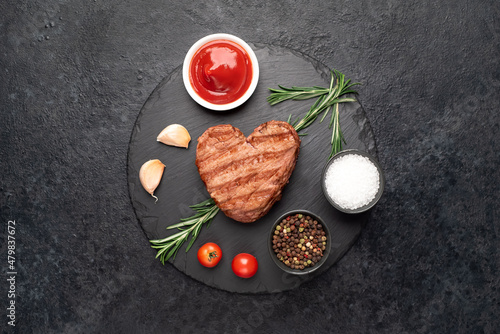 Heart shaped grilled beef steak with arrow for valentine's day on stone background