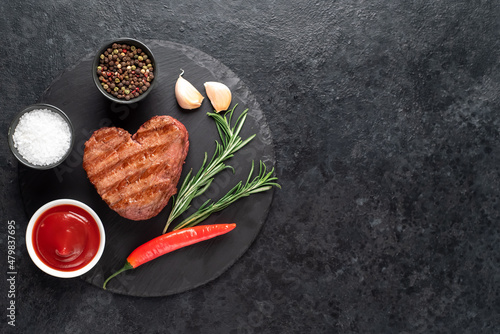 Heart shaped grilled beef steak for valentine's day on stone background with copy space for your text