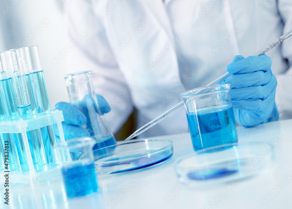 Fototapeta premium Scientist adds a laboratory pipette liquid to a petri dish, selective focus. Development of a vaccine for children against Covid-19