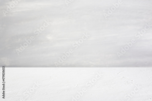 White concrete perspective table top background, with grey textured wall. Empty space for text, copy or product display mockups. Use as a template for digital product placement and marketing. 