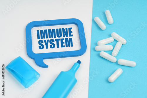 On the white and blue surface are a marker, tablets and a plate inside which the inscription - Immune System