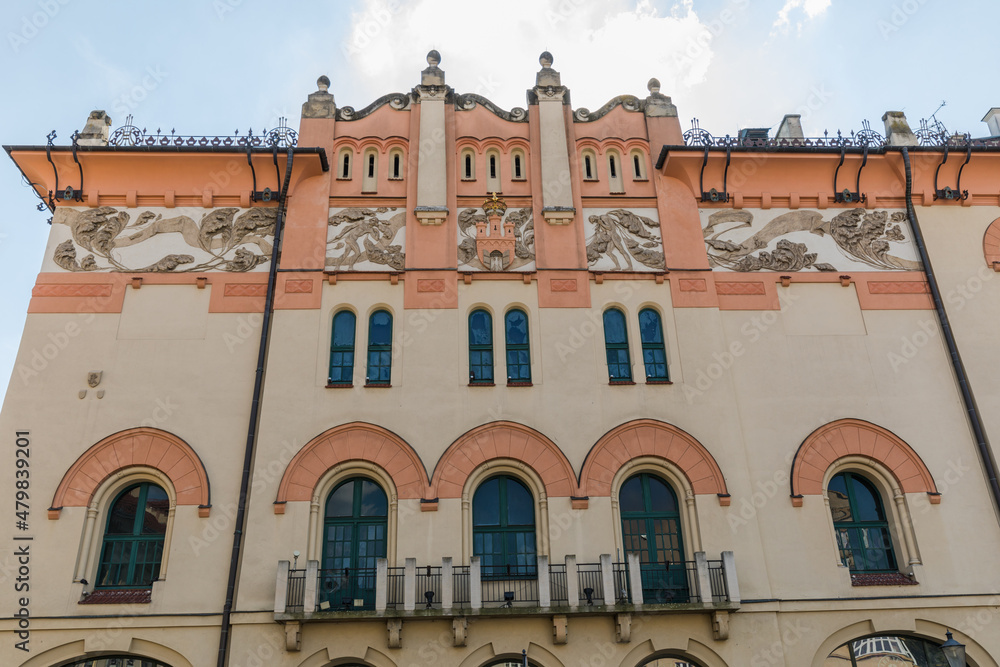 Obraz premium The facade of a tenement house with windows and the coat of arms of the city of Krakow.