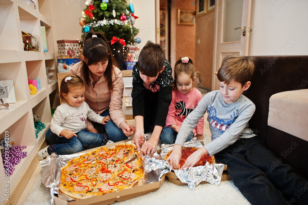Happy family with four kids eating pizza at home. Happy family with four kids eating pizza at home.