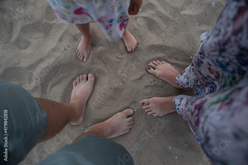 Family feet in the sands of the sea, feet on the beach, parent and child 