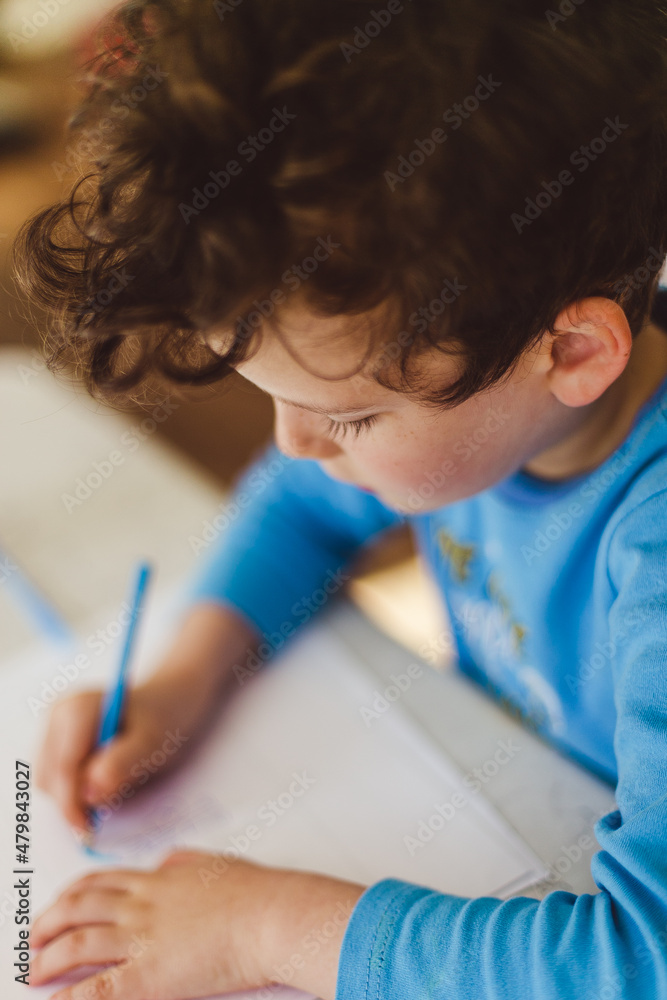 Boy in the blue pajamas writing or drawing something Boy in the blue pajamas writing or drawing something