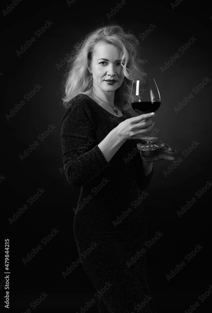 Attractive middle age woman in black evening dress with glass of red wine. Attractive middle age woman in black evening dress with glass of red wine.