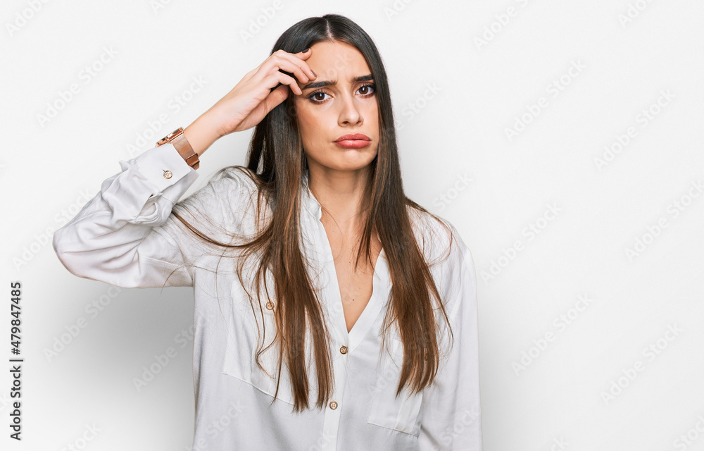 Young beautiful woman wearing casual white shirt worried and stressed about a problem with hand on forehead, nervous and anxious for crisis Young beautiful woman wearing casual white shirt worried and stressed about a problem with hand on forehead, nervous and anxious for crisis
