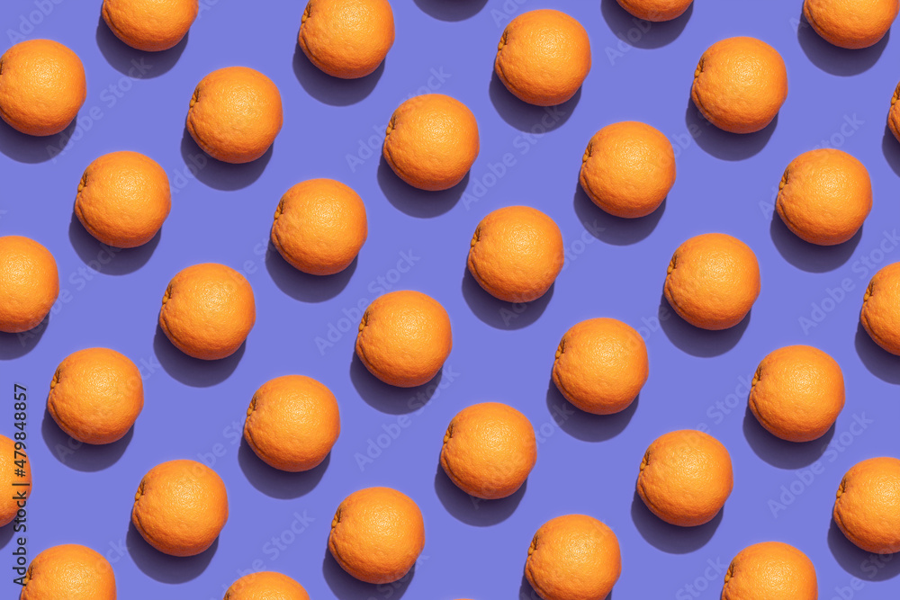 Fruit oranges in checkered pattern on violet background. Violet and orange colors background from fruity oranges. Demonstrating very peri, color of 2022 year.