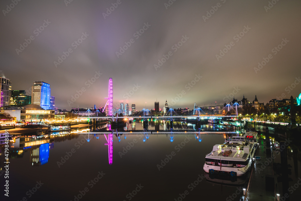 Evening skyline of London seen across Thames river 