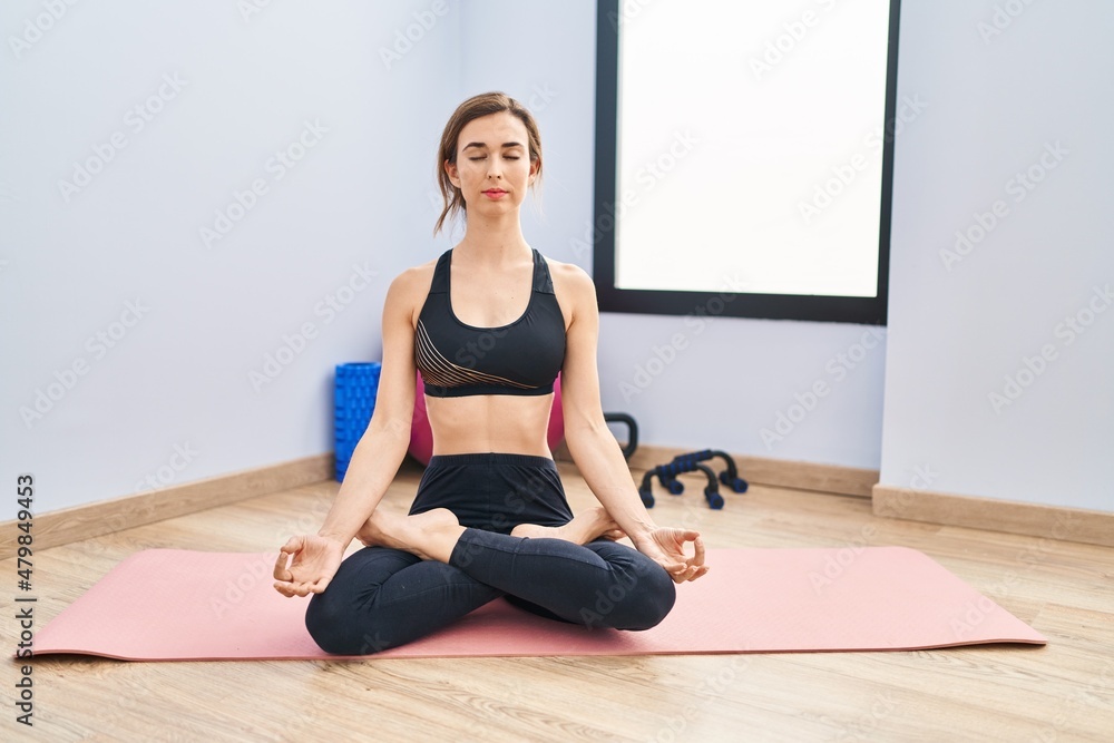 Young woman training yoga at sport center