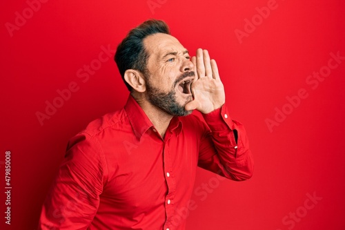 Middle age man wearing casual clothes shouting and screaming loud to side with hand on mouth. communication concept. © Krakenimages.com