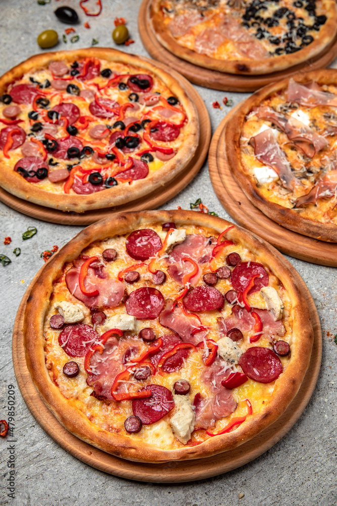 Pizza party dinner. Flat-lay of different kinds of Tasty hot Italian pizza on a beige textured background. Fast food lunch, gathering, celebration. Pizzeria Pizza party dinner. Flat-lay of different kinds of Tasty hot Italian pizza on a beige textured background. Fast food lunch, gathering, celebration. Pizzeria