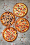 Pizza party dinner. Flat-lay of different kinds of Tasty hot Italian pizza on a beige textured background. Fast food lunch, gathering, celebration. Pizzeria 
