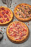 Pizza party dinner. Flat-lay of different kinds of Tasty hot Italian pizza on a beige textured background. Fast food lunch, gathering, celebration. Pizzeria 