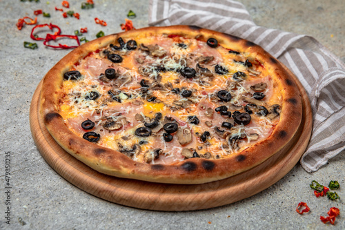 Tasty hot italian pizza with Mozzarella, Ham, mushrooms, olives and Tomato Sauce on a beige textured background. Pizzeria menu. 