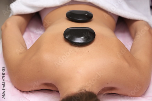Black massage heated volcanic rock. Heated basalt river stones. Therapist stone massaging