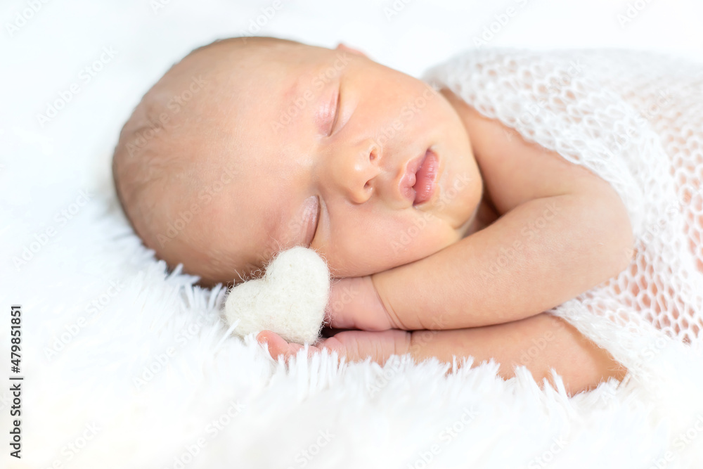Newborn baby sleeping on a white background. Selective focus. Newborn baby sleeping on a white background. Selective focus.