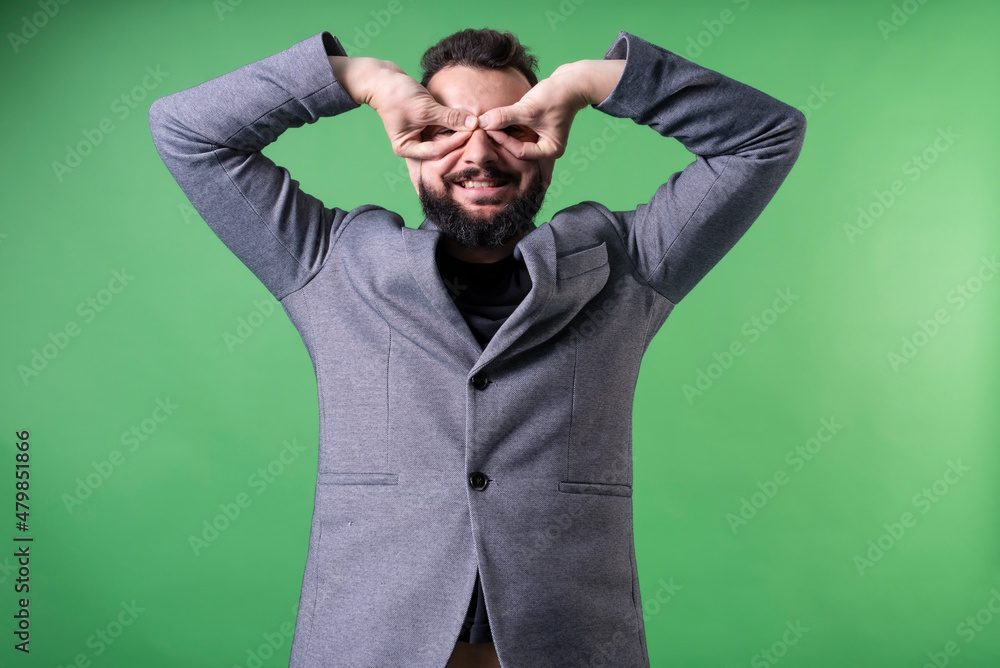 elegant man in suit makes glasses with his hands as a fake mask elegant man in suit makes glasses with his hands as a fake mask