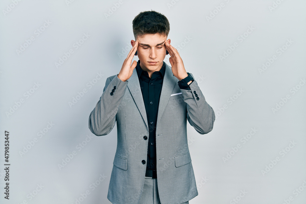 Young caucasian boy with ears dilation wearing business jacket with hand on head, headache because stress. suffering migraine. Young caucasian boy with ears dilation wearing business jacket with hand on head, headache because stress. suffering migraine.