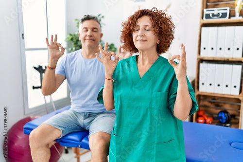 Fototapeta Naklejka Na Ścianę i Meble -  Physiotherapy woman working at pain recovery clinic with patient relax and smiling with eyes closed doing meditation gesture with fingers. yoga concept.