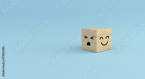 Wooden cube with anger and happy faces on blue background. Customer service evaluation.
