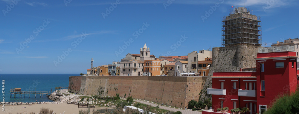 Panorama of the Swabian Castle of Termoli enclosed by the city walls with towers overlooking the Adriatic Sea and on the ancient fishing machine called Trabucco.