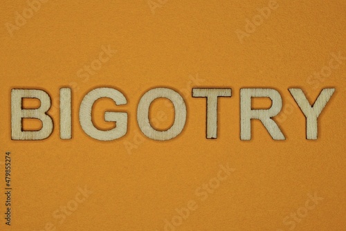gray word bigotry made of wooden letters on brown background
