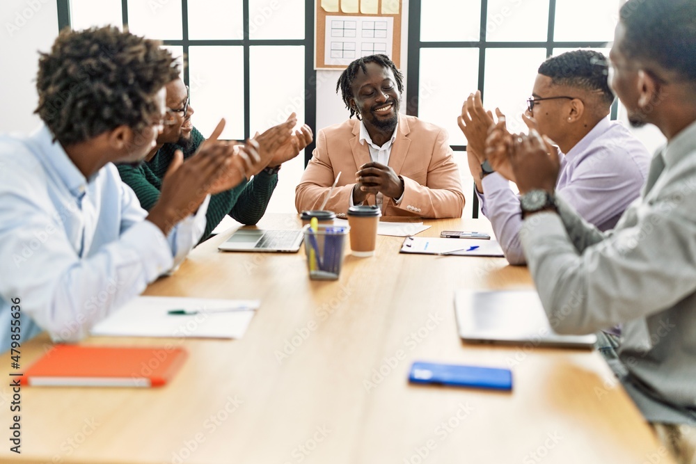 Group of african american business workers smiling and clapping to partner at the office. Group of african american business workers smiling and clapping to partner at the office.