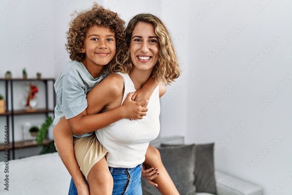 Mother and son smiling confident holding kid on back at home Mother and son smiling confident holding kid on back at home