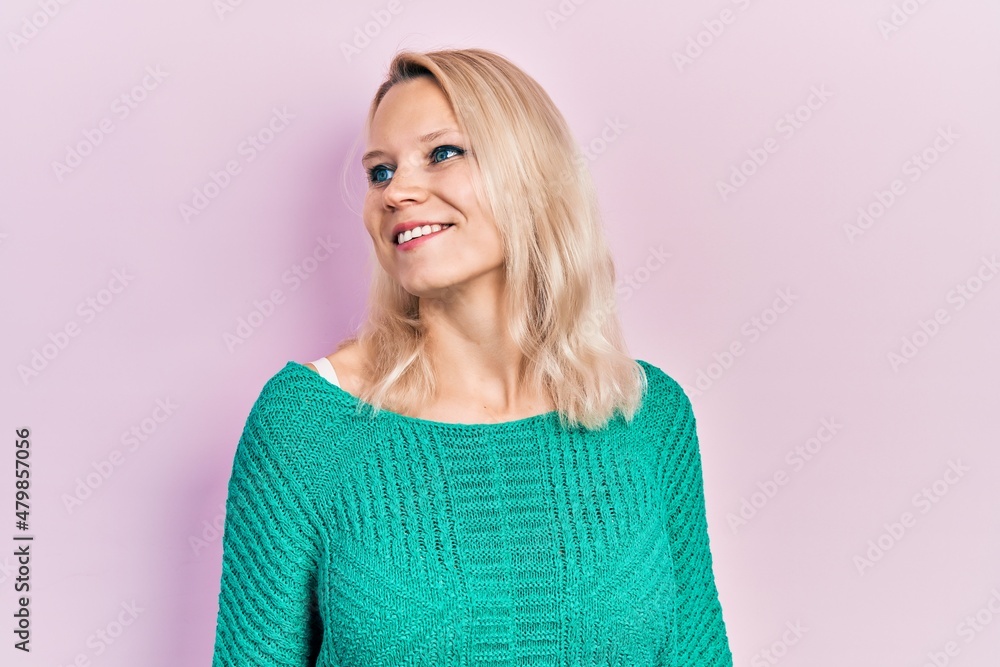 Beautiful caucasian blonde woman wearing casual winter sweater looking to side, relax profile pose with natural face and confident smile. Beautiful caucasian blonde woman wearing casual winter sweater looking to side, relax profile pose with natural face and confident smile.