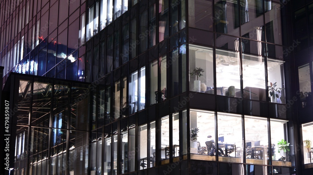 Office building at night, building facade with glass and lights. View with illuminated modern skyscraper. Office building at night, building facade with glass and lights. View with illuminated modern skyscraper.