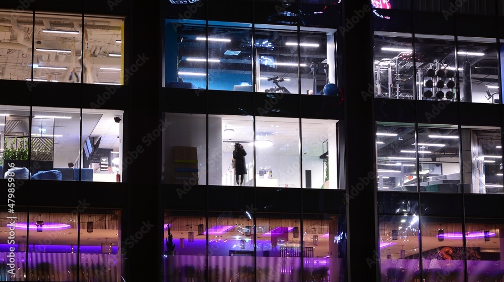 Office building at night, building facade with glass and lights. View with illuminated modern skyscraper. Office building at night, building facade with glass and lights. View with illuminated modern skyscraper.