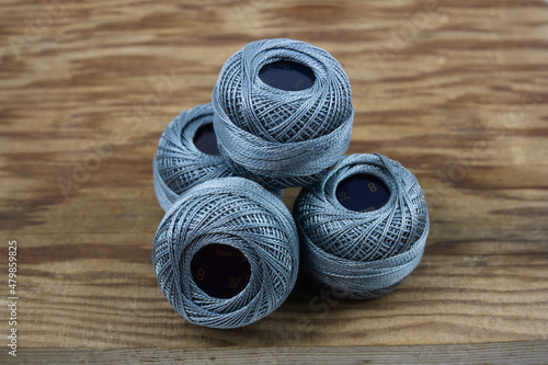 Close-up of some balls of quality gray pearl thread on an old wood