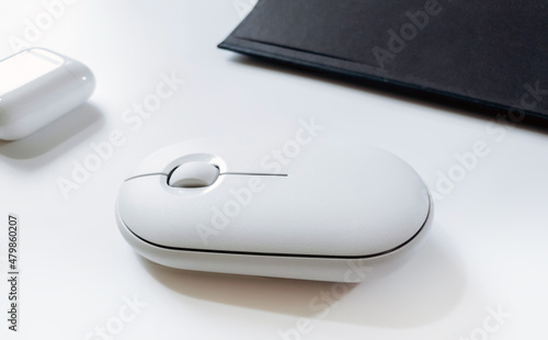 Computer white mouse in hand with notepad and laptop on a white background in banner format