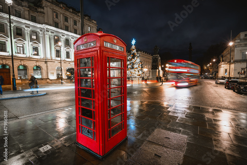 Christmas time in London with red telephone booth in front of an illuminated Christmas Tree