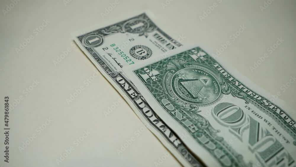 Macro video shooting wide angle. Close-up shot of isolated US dollar bills being laid on the surface. Money is falling from the top. 1 dollar banknote and 100 dollars. Cash withdrawal. Money Macro video shooting wide angle. Close-up shot of isolated US dollar bills being laid on the surface. Money is falling from the top. 1 dollar banknote and 100 dollars. Cash withdrawal. Money
