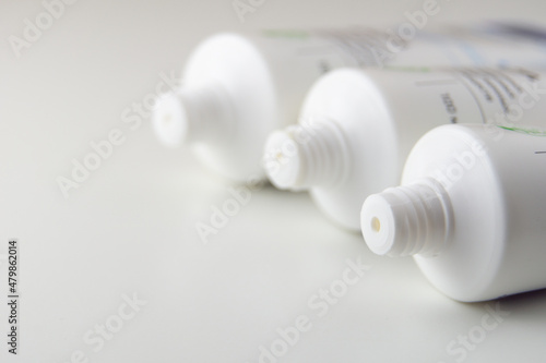 Three tubes of cream lie on a white background. Three open creams lie side by side.