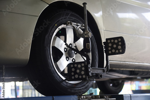 Mechanic installs sensor for wheel alignment job in repair shop.balancing wheel with aligner