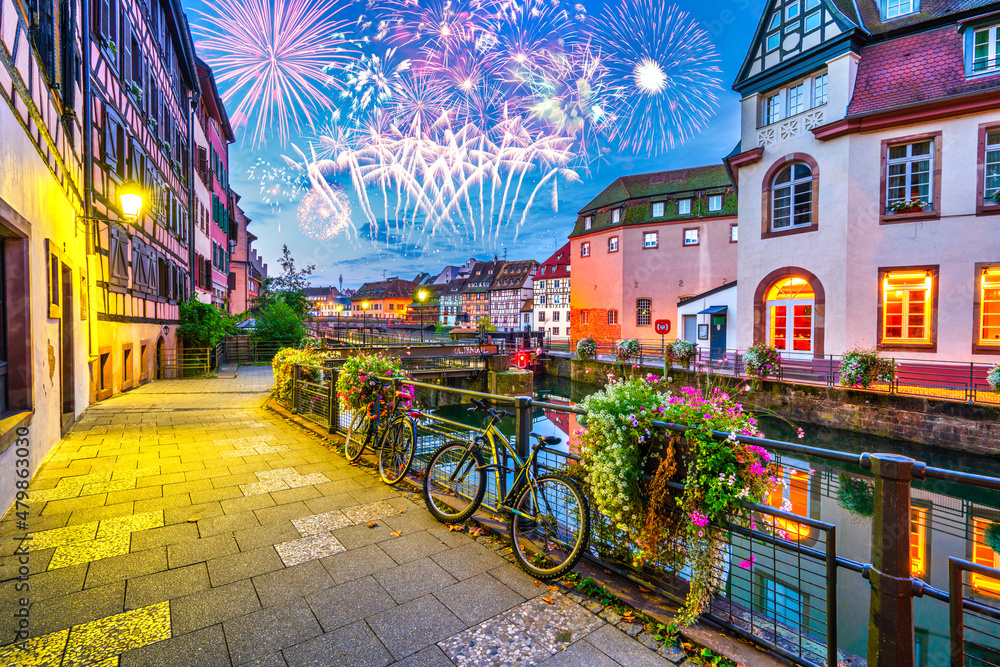 Fireworks at the old town water canal panorama of Strasbourg, Alsace, France. Traditional half timbered houses of Petite France