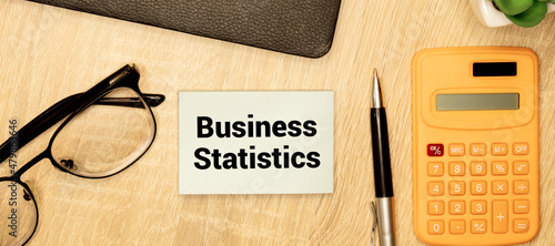 Text BUSINESS STATISTICS on sticker on notepad on diagram background.
