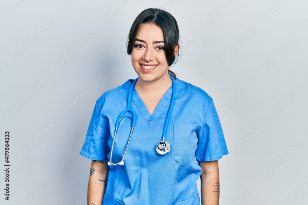 Beautiful hispanic woman wearing doctor uniform and stethoscope with a happy and cool smile on face. lucky person. Beautiful hispanic woman wearing doctor uniform and stethoscope with a happy and cool smile on face. lucky person.