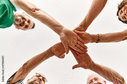 Group of middle age friends with hands together. © Krakenimages.com