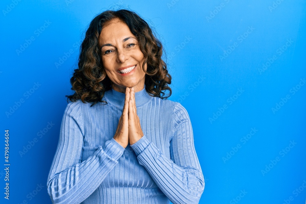 Middle age hispanic woman wearing casual clothes praying with hands together asking for forgiveness smiling confident. Middle age hispanic woman wearing casual clothes praying with hands together asking for forgiveness smiling confident.