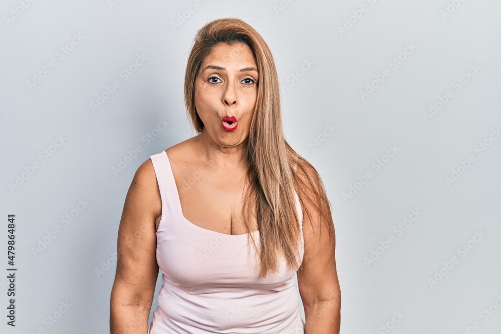 Middle age hispanic woman wearing casual style with sleeveless shirt afraid and shocked with surprise expression, fear and excited face. Middle age hispanic woman wearing casual style with sleeveless shirt afraid and shocked with surprise expression, fear and excited face.
