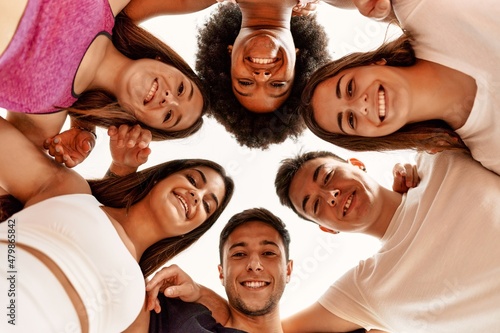 Group of young sporty people smiling happy and hugging with heads together looking to the camera at sport center. © Krakenimages.com